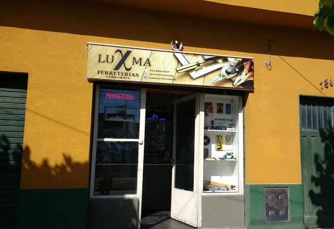 Frente de Luxma: pared mostaza, cartel de madera y vidriera